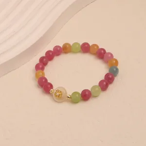 Macro view of a colorful tourmaline crystal beaded bracelet with vibrant candy-colored stones.