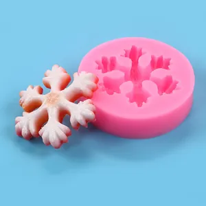 Detail of snowflake silicone mold with a finished pink and white resin snowflake ornament