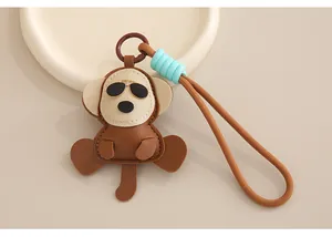 Vue détaillée d'un charm de sac en cuir singe avec dragonne tressée marron anti-perte