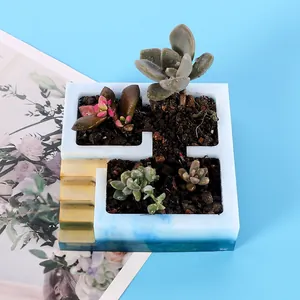 Dettaglio vaso quadrato per succulente in resina con finitura marmorizzata blu.
