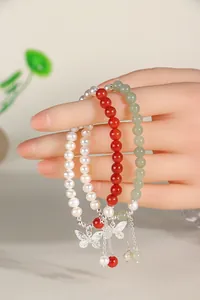 Detail of three-piece beaded bracelet set with pearls, agate and butterfly charms