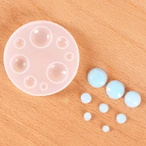 Dettaglio dello stampo circolare in silicone per resina con sfere azzurre su legno