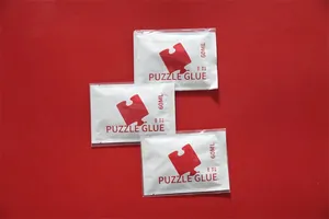 Drei einzelne 60 ml Beutel mit klarem PVA-Puzzlekleber auf solidem rotem Hintergrund