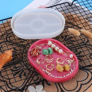 Detailed view of DIY oval silicone mold with finished red glitter resin jewelry tray