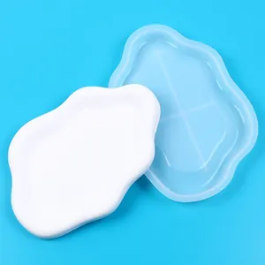 Detail view of a cloud-shaped silicone mold with its white finished product on blue.