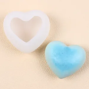 Vue rapprochée d'un moule en silicone en forme de cœur avec une bougie ou savon bleu.