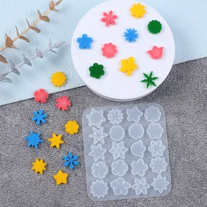 Macro detail of DIY silicone mold showing various mini snowflake and floral shapes for resin