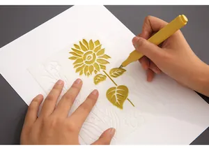 Close-up of a hand using a yellow marker with a sunflower PET hollow drawing stencil.