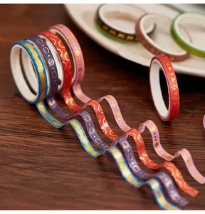 Detail of gold foil washi tapes with heart and geometric patterns on wood.