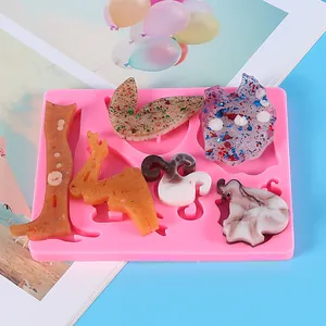Close-up of pink silicone angel mold with finished resin glitter pieces