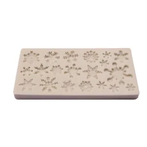 Detail view of a flexible silicone baking mold with various intricate snowflake patterns.
