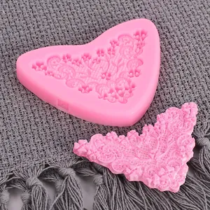 Vue détaillée d'un moule en silicone rose en forme de cœur avec des motifs floraux en relief.