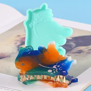 Close-up of cat-shaped DIY silicone mold and colorful resin hair clip accessories.