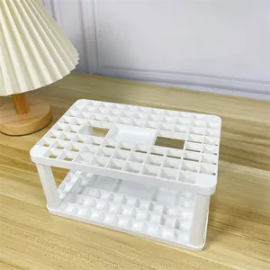 Κοντινή όψη λευκής θήκης οργάνωσης γραφείου με πολλές τρύπες για πινέλα και γραφική ύλη