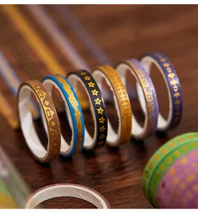 Detailed close-up of colorful washi tape rolls with elegant gold foil patterns
