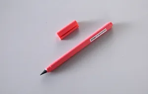 Close-up of a pink inkless eternal pencil with cap removed on a plain background.