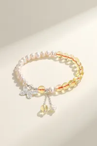 Elegant freshwater pearl bracelet featuring a silver butterfly charm and translucent yellow beads