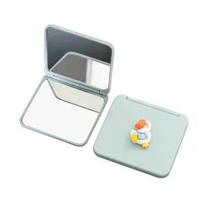 Portable mini folding makeup mirror with cute cartoon duck design on light blue cover