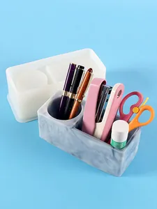 Detail of DIY silicone mold and finished marble texture resin pen holder on blue background