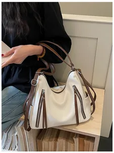 Close-up detail of large capacity white hobo bag with brown straps and stylish zipper accents