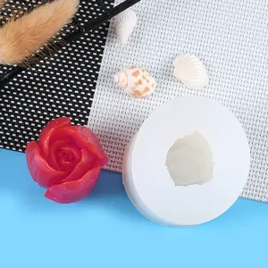 Detailed view of white tulip flower silicone mold next to a red finished candle result