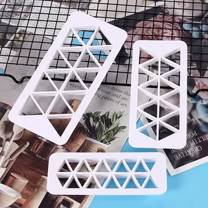 Three-piece white plastic geometric triangle pattern cookie and cake cutters for DIY baking.