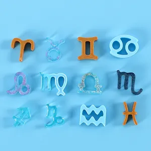 Collection of twelve colorful resin zodiac charms displayed on a blue background.