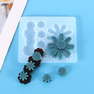 Gros plan du moule en silicone pour barrettes en fleurs DIY avec pièces en résine sarcelle.