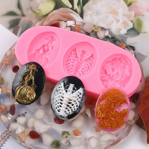 Detail of pink silicone mold with Gothic skeleton and angel relief for DIY crafts.