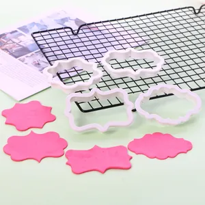 Detail van vier fondant uitstekers met roze deeguitstulpingen op een afkoelrooster