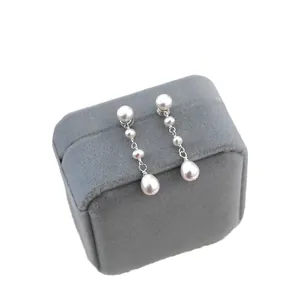 Elegant freshwater pearl long drop earrings displayed on a premium grey velvet jewelry box