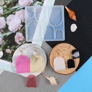 Vista dettagliata di uno stampo in silicone con campioni di orecchini in resina DIY.