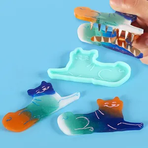 Detailed view of cat-shaped silicone mold and finished resin hair clips for DIY jewelry