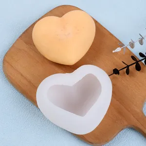 Gros plan détaillé d'un moule en silicone en forme de cœur et d'une bougie finie sur bois