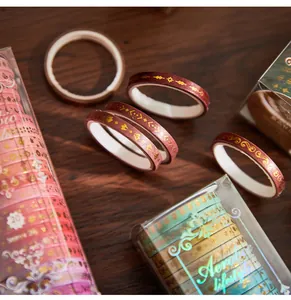 Close-up of Aerobic Lifestyle washi tape set with decorative gold foil patterns on wood