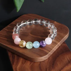 Detailansicht eines Bergkristall-Armbands mit bunten Kristallperlen auf Holz