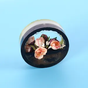 Detailed view of a circular wall-mounted resin flower pot with pink artificial flowers