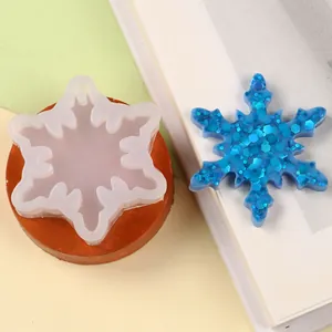Close-up of snowflake silicone mold with a blue glittery resin snowflake piece