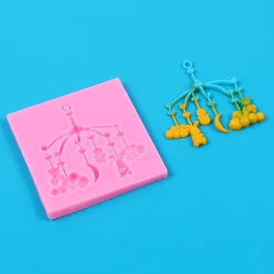 Dettaglio di uno stampo in silicone rosa e creazioni in resina per mobile bimbo