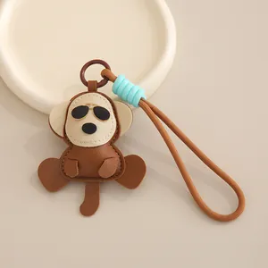 Porte-clés en cuir singe de dessin animé avec lanière tissée marron et détail de nœud bleu