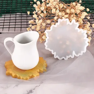 Detail view of irregular snowflake-shaped silicone mold and finished resin coaster.