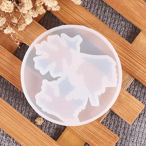 Primer plano de un molde de silicona translúcido con forma de hoja de arce para resina DIY