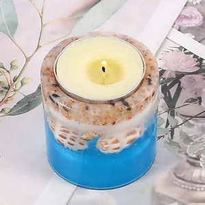 Close-up of ocean theme resin candle holder with seashells and sand for aromatherapy