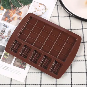 Stampo in silicone marrone per cioccolato con cavità multiple su tovaglia a scacchi.