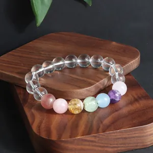 Makro-Detail eines Bergkristall-Armbands mit bunten Edelsteinperlen auf Holzsockel
