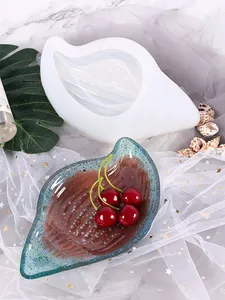 Dettaglio dello stampo in silicone a conchiglia e del vassoio in resina glitterata.