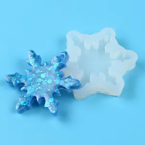 Detailed view of a snowflake silicone mold alongside a glittery blue resin finished piece