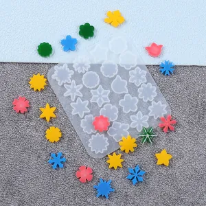 Detailed macro view of snowflake and flower silicone mold with colorful resin jewelry pieces