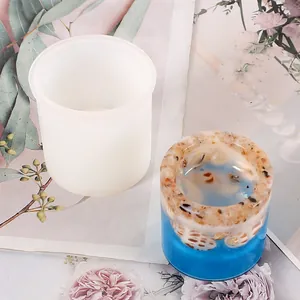 Close-up of cylindrical silicone mold and blue resin finished candle holder
