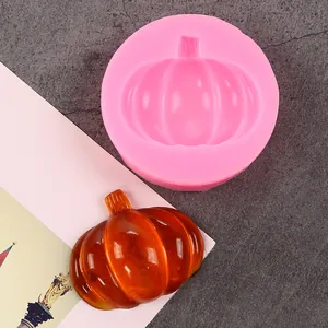 Detail view of pink silicone pumpkin mold alongside a finished orange resin craft
